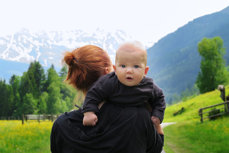 Baby and mother with the Alps mountains in nature in the Backgroundの写真素材
