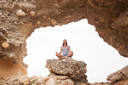 Woman doing yoga on the sea backgroundの写真素材