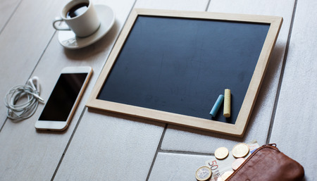 Chalkboard or Blackboard ready for text. Education or working, business, job concept. Stylish office background with coffee, wallet with euro money, mobile phone and headphones.の写真素材