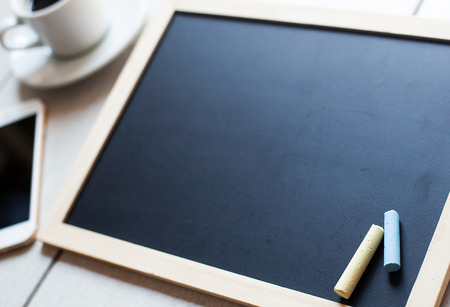 Chalkboard or Blackboard ready for text. Education or working concept. Stylish office background with coffee and mobile phone.の写真素材