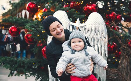 Happy family spend time at a Christmas street market fair in the old town of Salzburg, Austria....