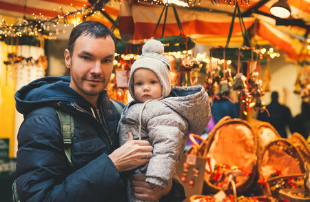 Happy family spend time at a Christmas and New Year holidays in the old town of Salzburg, Austria. Holidays, Christmas, Family concept. Father and son at winter outdoor among Christmas decorationsの写真素材