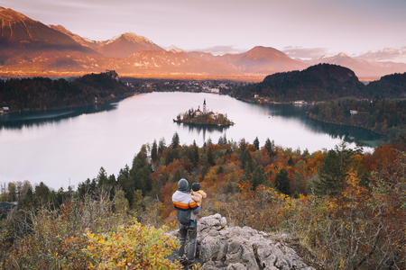 Father and his son looking sunset with amazing view on Bled Lake. Autumn or Winter in Slovenia, Europe.の写真素材