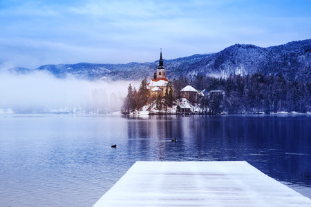 Winter landscape Bled Lake. Travel Slovenia, Europe. Bled Lake one of most amazing tourist attractions. View on snowy Island with Catholic Church in Bled Lake.の写真素材
