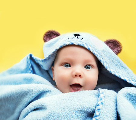 Cutest baby child after bath with towel on head. Adorable smiling baby boy!