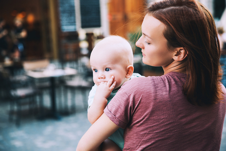Beautiful young mother with baby child spend time in the old town of Ljubljana, Slovenia, Europe. Mother and son are traveling and walking in a european city.の写真素材