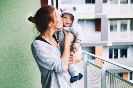 Portrait of a fashionable cute baby child in a hoodie romper. Mom and her son outdoors.の写真素材
