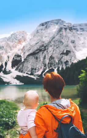 Family of tourists on walks on Braies Lake. Woman and baby girl on lake shore of Lago di Braies in Dolomites, South Tyrol, Italy, Europe. Beauty of nature image.の写真素材
