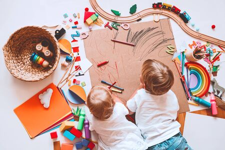 Kids draw and make crafts. Children with educational toys and school supplies for creativity. Background for preschool and kindergarten or art classes. Boy and girl play at home or daycareの写真素材