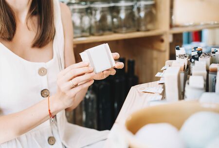 Woman with cotton bag buying personal hygiene items in zero waste shop. Eco Organic Cosmetics. Girl choose toiletries products in plastic free store. Minimalist lifestyle. Shopping at local businessesの写真素材