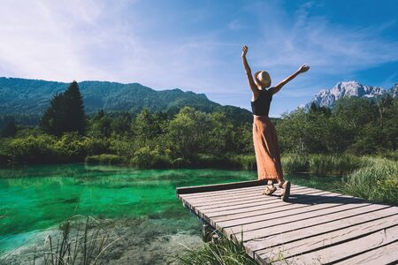 Young woman enjoying freedom on nature outdoors. Travel, Relaxation, Lifestyle Image. Amazing view on Zelenci (into English means - green) natural reserve in Slovenia, Europe. Nature background.の写真素材