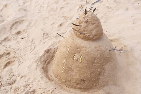 New Year or Merry Christmas sandy snowman on tropical ocean sand beach. Background lifestyle image of winter vacation in warm countries. Family holiday on Tenerife, Spain.の写真素材