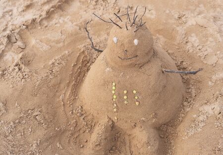 New Year or Merry Christmas sandy snowman on tropical ocean sand beach. Background lifestyle image of winter vacation in warm countries. Family holiday on Tenerife, Spain.の写真素材