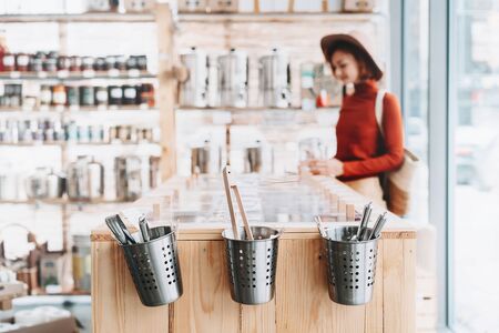 Background of interior in zero waste shop. Customer buying dry goods and bulk products in plastic free grocery store. Image of conscious shopping, sustainable small businesses, minimalist lifestyleの写真素材