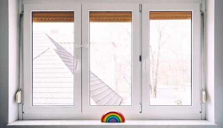 Wooden rainbow toy on background of window in nursery at home. Children background.