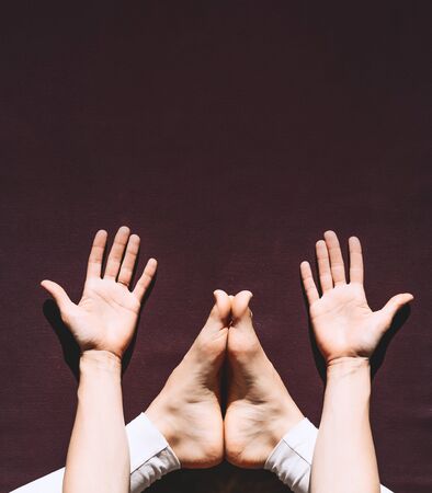 Young woman practicing yoga on yoga mat indoors. Girl meditating and doing relaxing yoga poses at home. Female training for health body and mind. Concept of no stress, female happiness and zen energyの写真素材