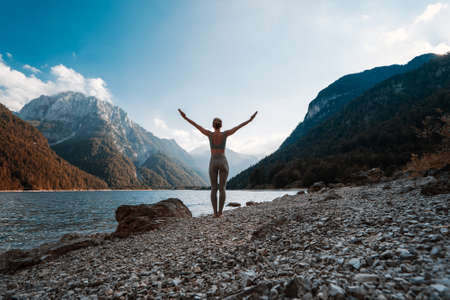 Image of yoga inspiration on nature. Young woman with yoga mat gets ready to practicing yoga outdoor. Beautiful female with slim, strength body in white clothes. Healthy and conscious lifestyles.の写真素材
