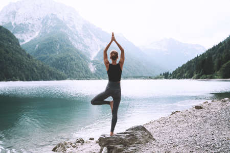 Image of yoga inspiration on nature. Young woman with yoga mat gets ready to practicing yoga outdoor. Beautiful female with slim, strength body in white clothes. Healthy and conscious lifestyles.の写真素材