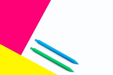 Color pens isolated on white background with pink and yellow elements. Minimalist design. Abstract geometric style. Flat lay. With copy space. Concept of work and education.の写真素材