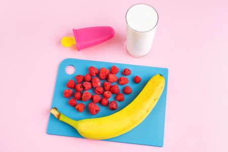 Step by step instruction. Homemade raspberry ice cream. Step 1. Prepare ingredients: banana, raspberry, glass of yogurt. Form for making ice cream. Home cooking concept. Hobby and activities at home.の写真素材