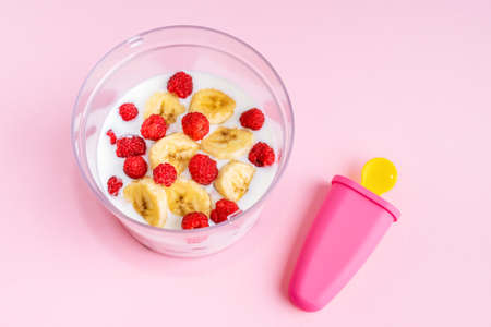 Step by step instruction. Homemade raspberry ice cream. Step 3. Put raspberries and banana in a blender, pour yogurt. Home cooking concept. Hobby and activities at home.の写真素材