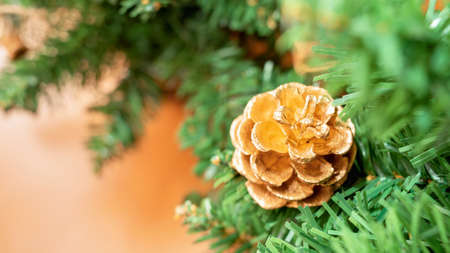 Beautiful decorated Christmas tree with a golden pine cone on blurred background. With copy space.の写真素材