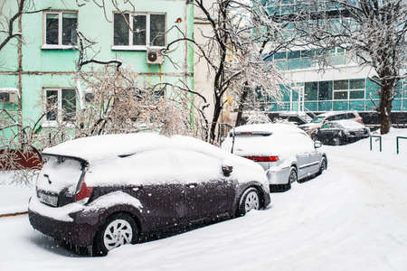 Vladivostok, Russia - November 20, 2020: Snowy road. Car covered with ice, snow, and icicles. Ice storm cyclone in November Vladivostok. Winter frosty weather.のeditorial素材