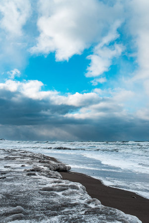 Winter landscape with frozen sea and icy beach. Storm and snow weather. Dramatic seascape.の写真素材