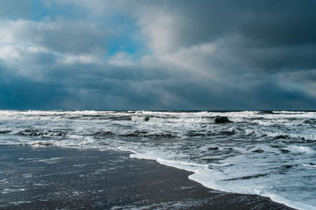 Winter landscape with frozen sea and icy beach. Storm and snow weather. Dramatic seascape.の写真素材
