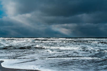 Winter landscape with frozen sea and icy beach. Storm and snow weather. Dramatic seascape.の写真素材