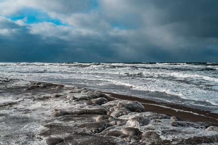 Winter landscape with frozen sea and icy beach. Dramatic seascape. Storm and snow weather.の写真素材