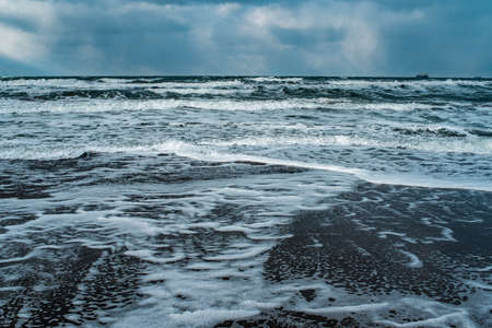 Winter landscape with frozen sea and icy beach. Storm and snow weather. Dramatic seascape.の写真素材