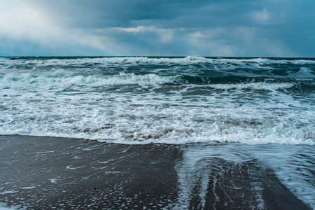 Winter landscape with frozen sea and icy beach. Storm and snow weather. Dramatic seascape.の写真素材
