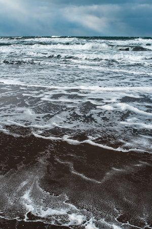 Winter landscape with frozen sea and icy beach. Dramatic seascape. Storm and snow weather.