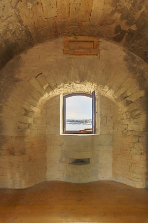 Window in an old dilapidated stone building with a vaulted ceiling. A sea portの写真素材