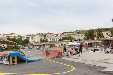 Russia, Crimea, Sevastopol - September 06.2017: Teens summer evening ride skateboards and bicycles on city streets. The area of the tercentenary of the Russian fleetのeditorial素材
