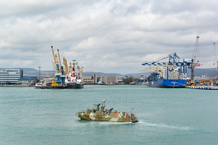 Russia, Novorossiysk - October 28.2017: Patrol boat in the waters of Novorossiysk commercial sea port. Berths are bulk carriersのeditorial素材