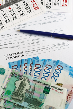 Payroll, calendar, ballpoint pen and banknotes of Russian money. Payment of wagesの写真素材