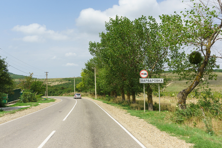 Car sign Overtaking is prohibited and the inscription in Russian Varvarovka. Entrance to the seaside village of Anapa district. Summer Sunny dayの写真素材