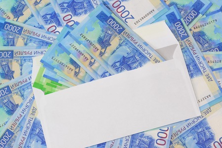 White envelope with money on the background of the new Russian two thousandth bills. Money as a giftの写真素材