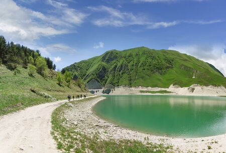 Dirt road on the shore of the mountain lake Kezenoi am in Botlikh district of the Republic of...