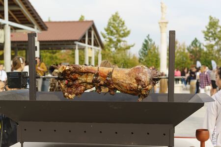 Moldavian, Crimea, Russia-05 October 2019: A whole carcass of sheep is roasted on a large spit. Delicious snack at the festival of young wine in the Valley of Lefkadiaのeditorial素材