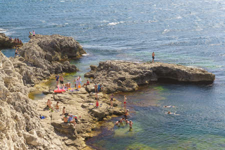 Tarkhankut, Crimea, Russia-September 11, 2019: People swim at Cape Tarkhankut. Stone spurs at the Western end of the Crimeaのeditorial素材