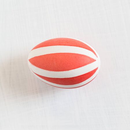 A traditional colored chicken egg for the spring festival Easter ritual. Pink drawing on a white backgroundの写真素材