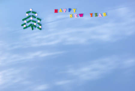 A Christmas tree made of green capsules and white pills and the inscription Happy new year on a blue...