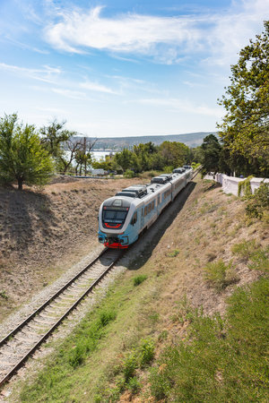 Russia, Crimea, Feodosia September 18, 2020-an electric locomotive with passenger cars goes Through...