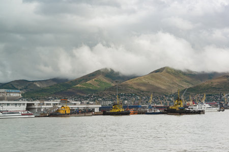 Novorossiysk, Russia, August 13, 2021: View from the western shore of the bay to the port and mountains. Southern city on a cloudy summer dayのeditorial素材