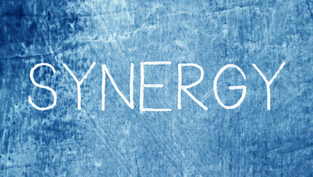 Synergy concept on blue chalky grunge backgroundの写真素材