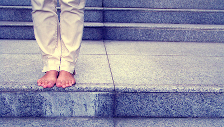 Barefoot female standing on stair step of marbel stone