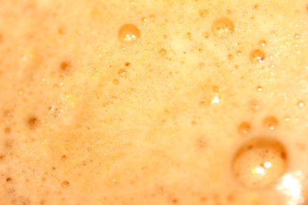 Orange frothy drink bubbles background closeupの写真素材
